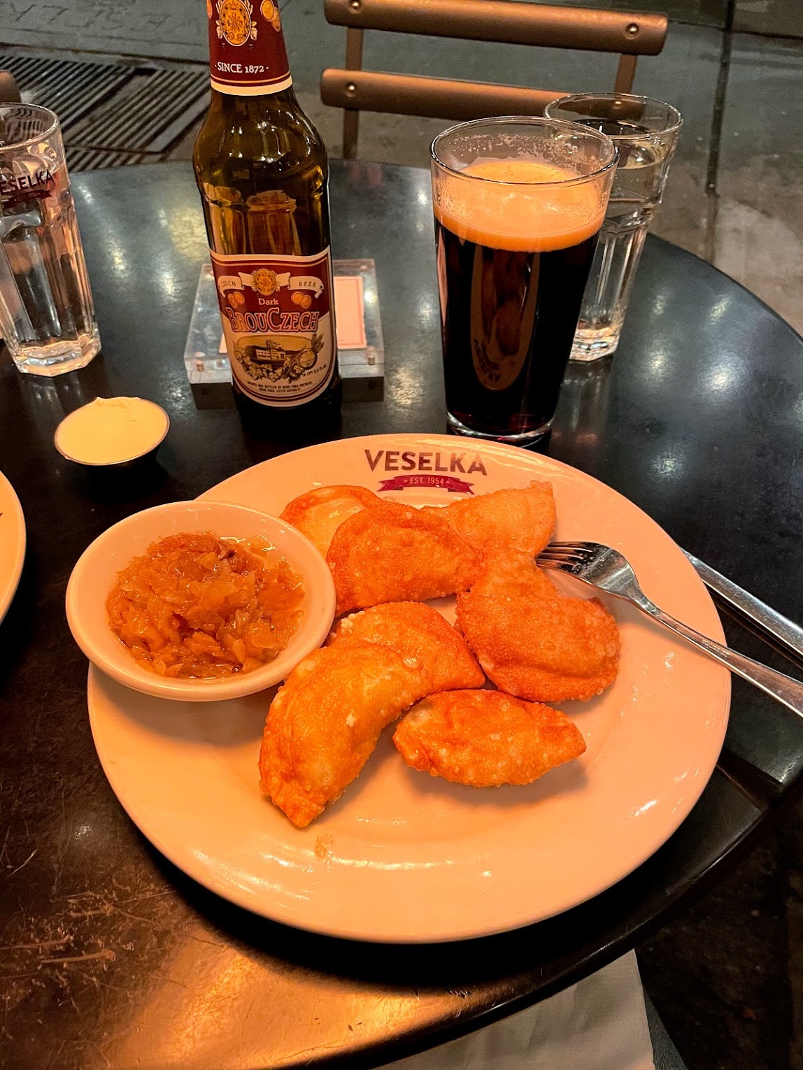 plate of pierogi and a dark beer